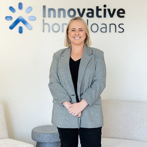 A woman standing in front of an innovative home loans sign.
